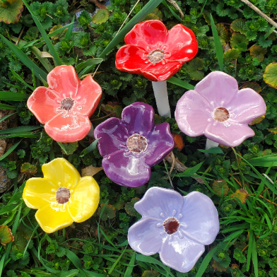 6 porcelain glazed flowers in purple, yellow, dark purple, red, and periwinkle